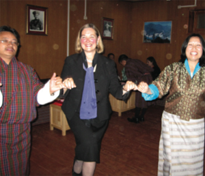 Photo of Martinez, rosy-cheeked and smiling, in a dance with locals.