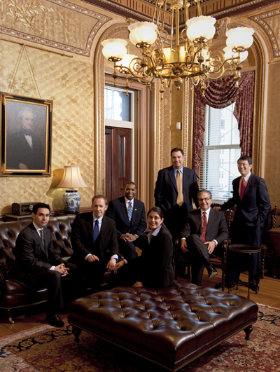 Gonzalez, Weideman, West, Tompkins, Camunez, Rivkin, and Fong dressed formally and seated in a stately room.