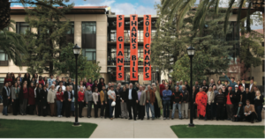 Photo of Stanford Law School faculty and staff gathered in front of the almost completed William H. Neukom Building