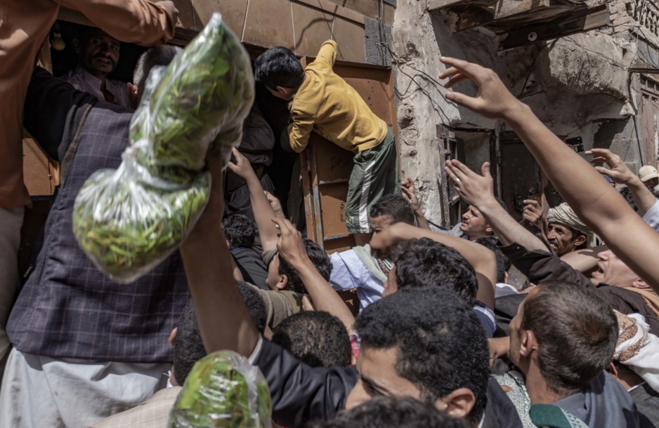 People at a local market in Yemen reaching for khat