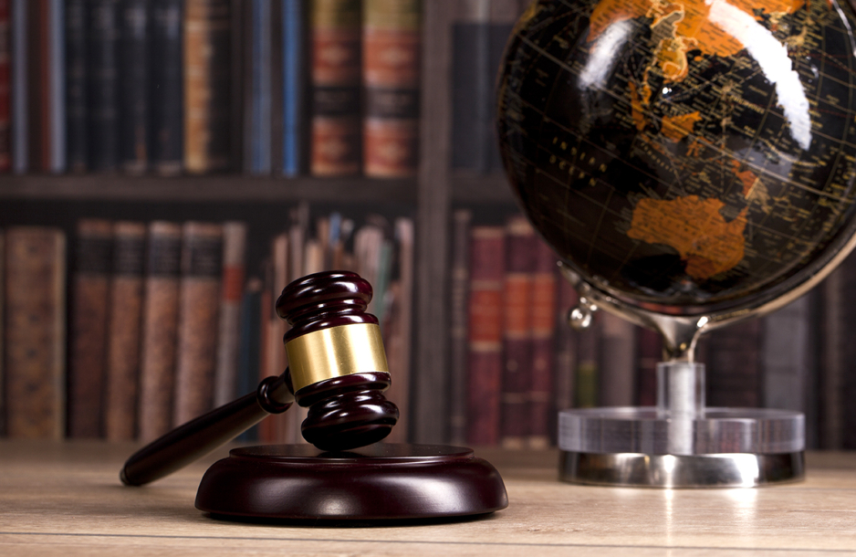 Law and justice symbols in a library with a globe.