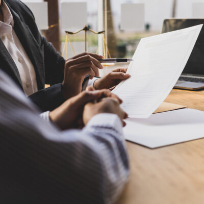 Closeup of two people seated at a table going over a contract.