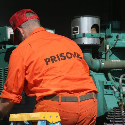 Image of a prisoner working on machinery.