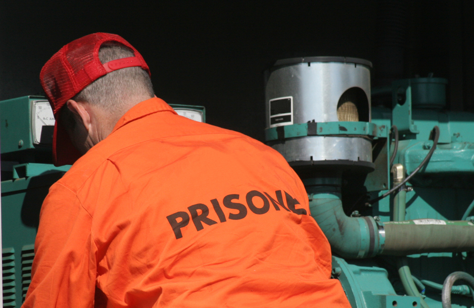 Image of a prisoner working on machinery.