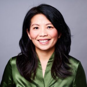 Photo of Nikki Vo, in a green blouse, smiling for a portrait